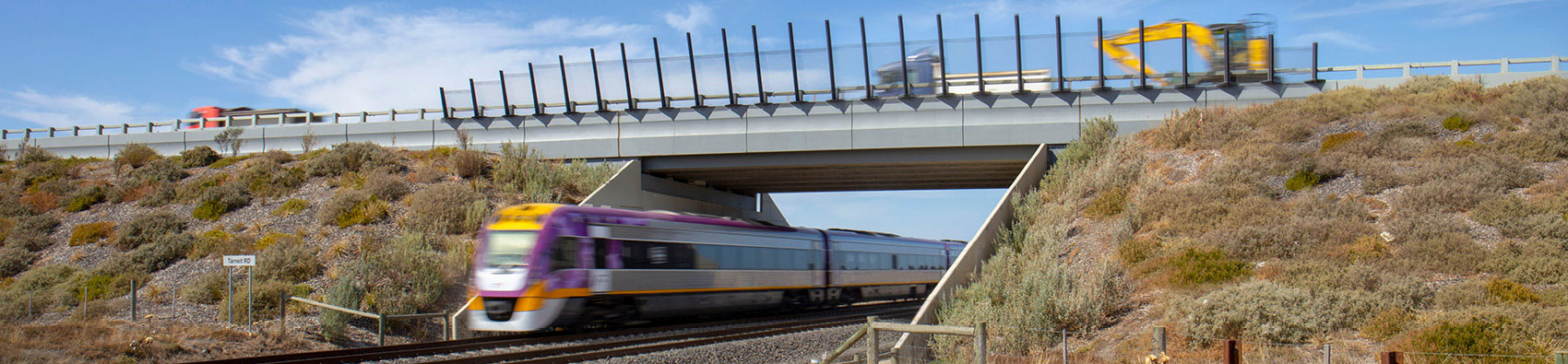 A V/Line train passing under a rail bridge