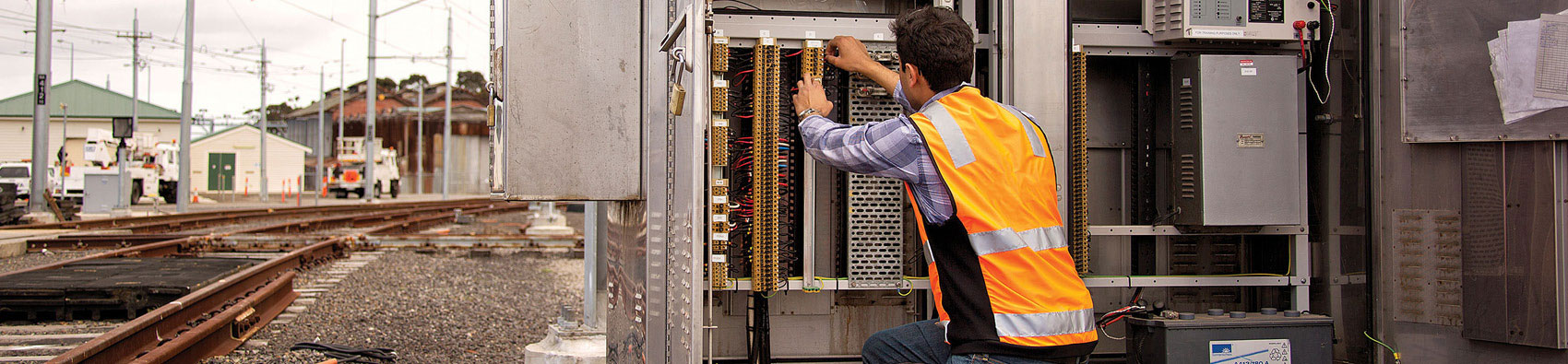 A worker wearing hi vis and working with telecommunications equipment.