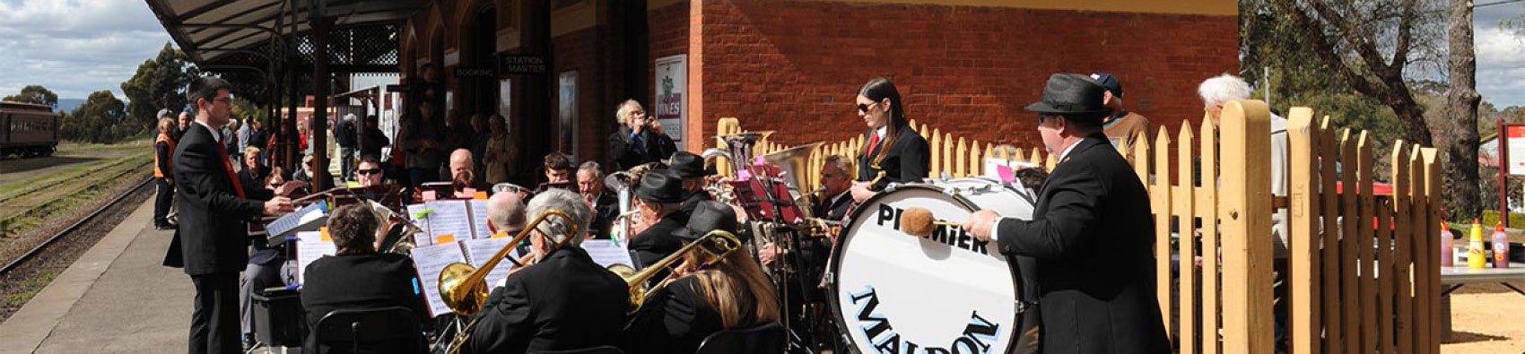 A band of musicians standing on the Maldon Station platform. Some of the musicians have drums and trumpets.
