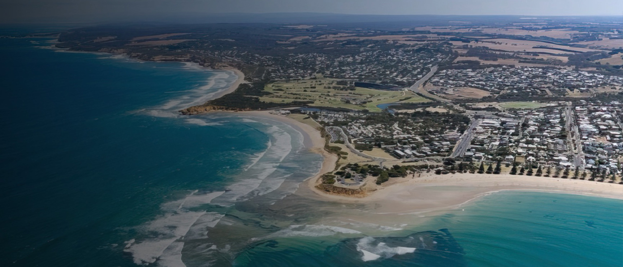 An aerial view of Geelong showing the shoreline and the beach with houses in the background